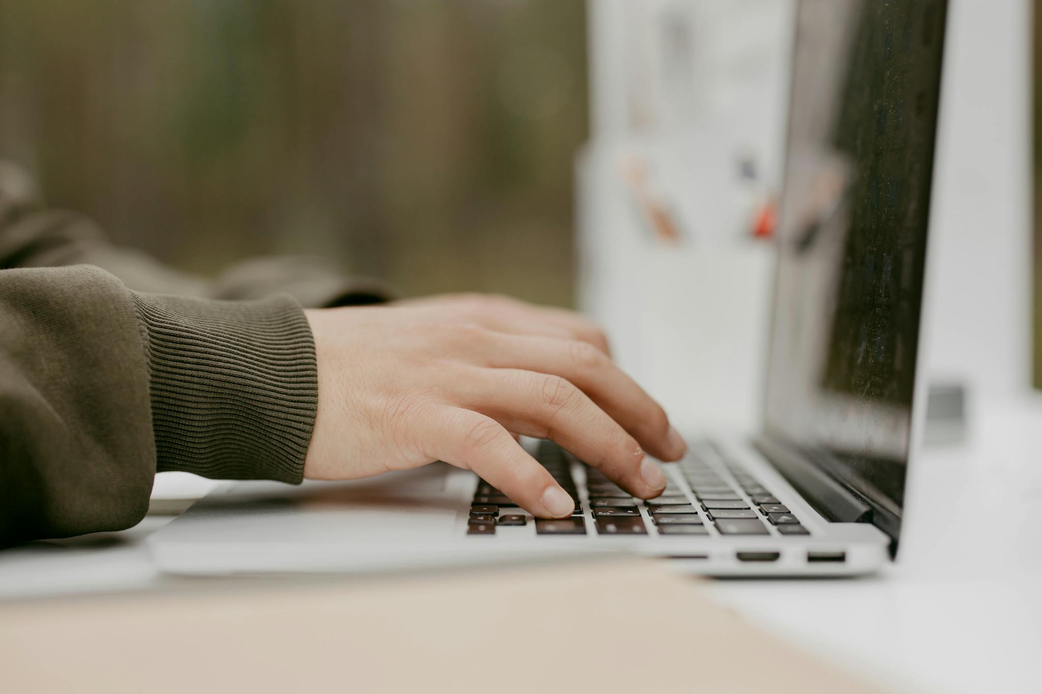 Home Close-up of hands typing on a laptop keyboard, ideal for technology and lifestyle themes.